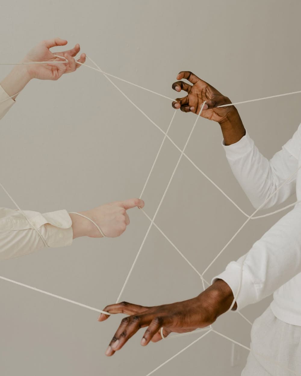Hands pulling tangled threads between them
