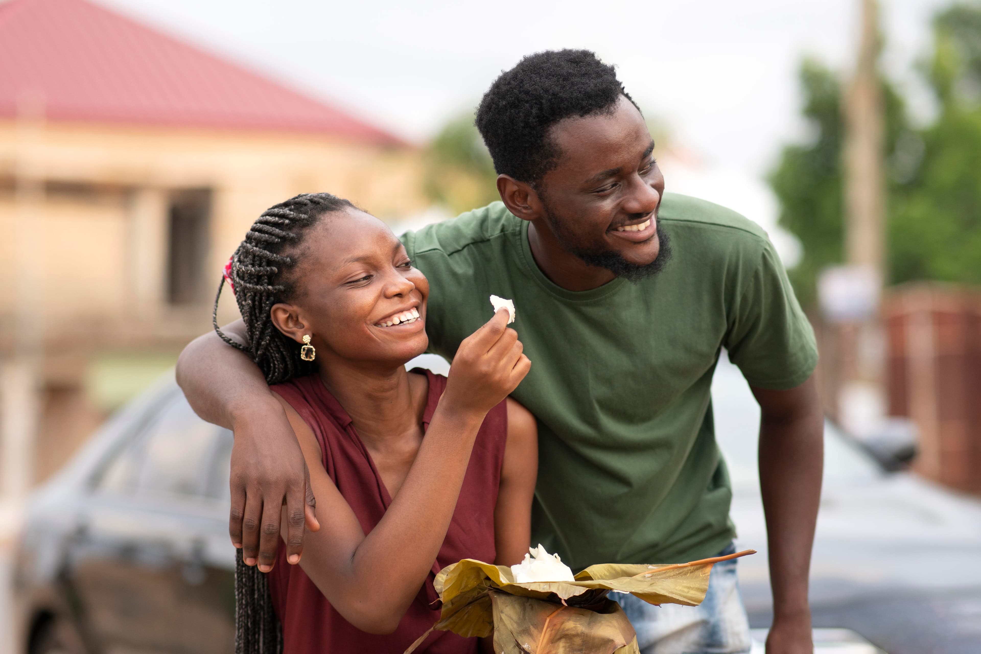 Smiling couple outdoors, the man’s arm around the woman