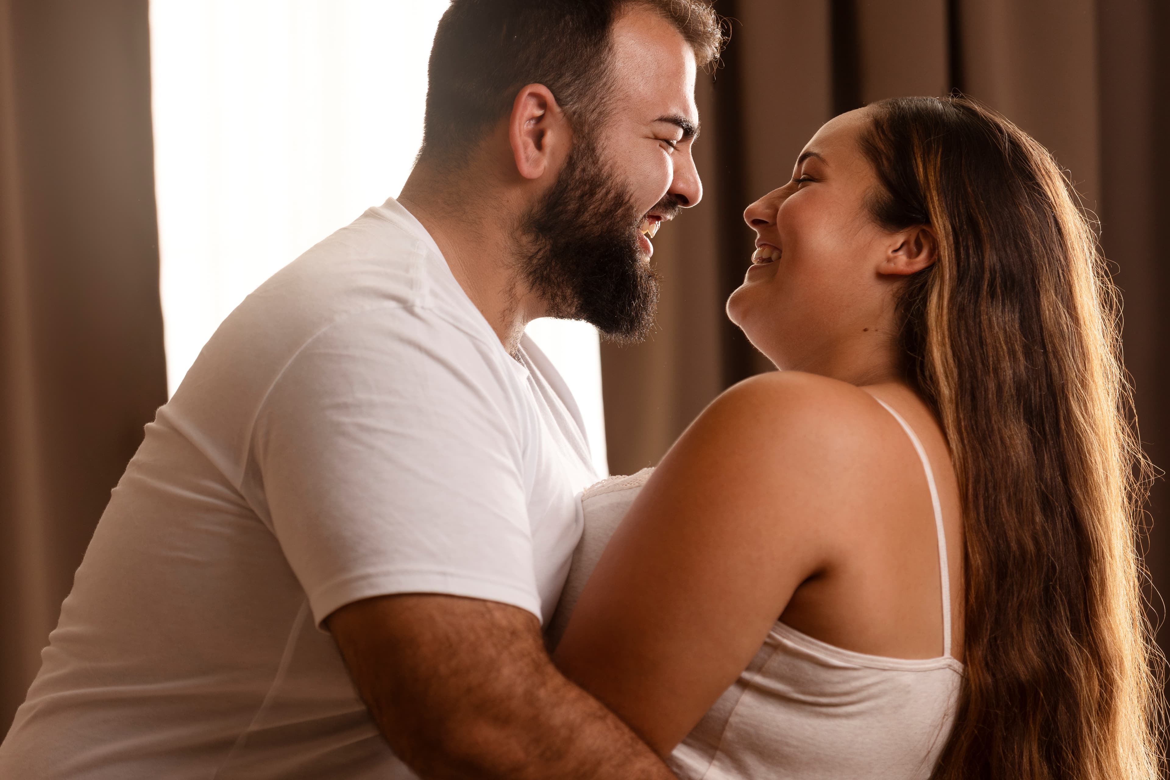Couple laughing together, faces close
