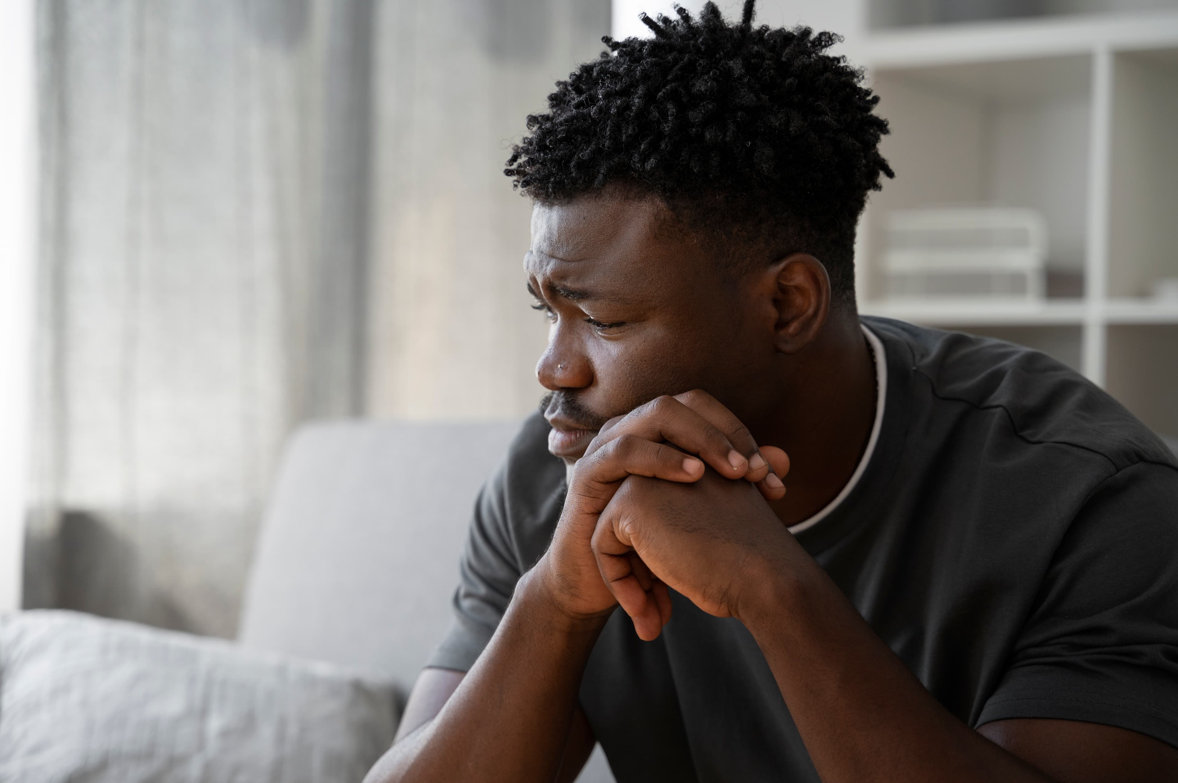 Man resting his chin on his hands, looking worried